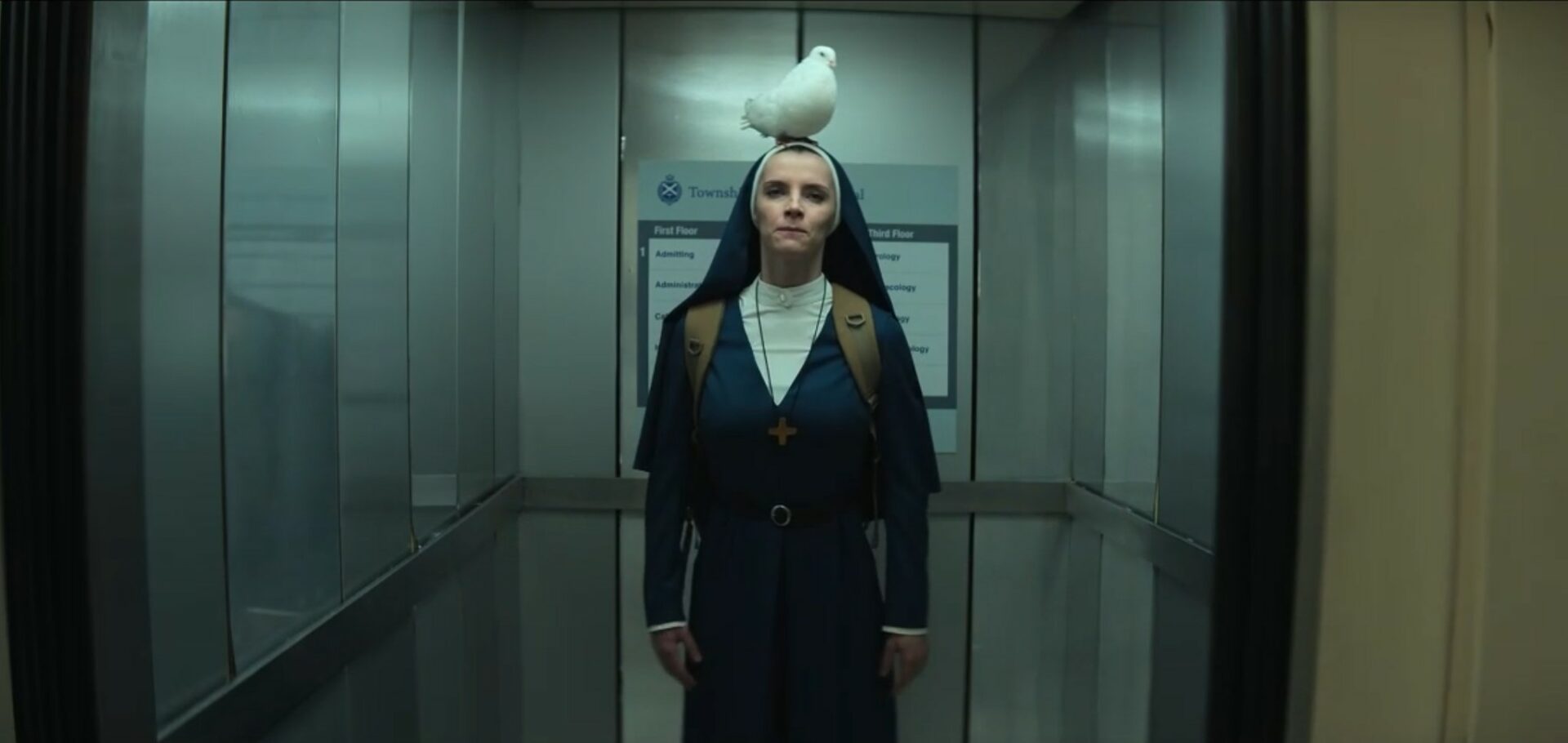 Mrs. Davis S1E4 - Sister Simone stands straight in an elevator with a pigeon on her head