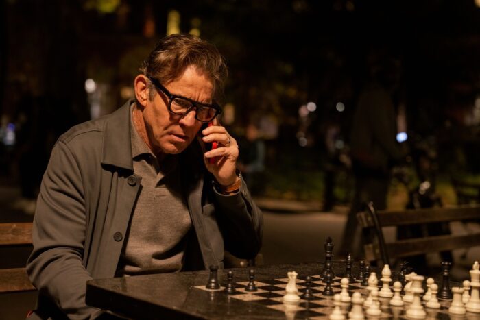 Jeff on the phone as he sits at a chess table at Washington Square Park