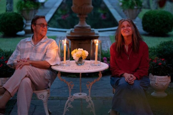 Eli and May-May sit happily at a small table with candles in the garden.