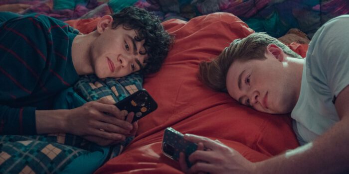 Joe Locke as Charlie Spring and Kit Connor as Nick Nelson laying next to each other testing at Charlie's sleepover