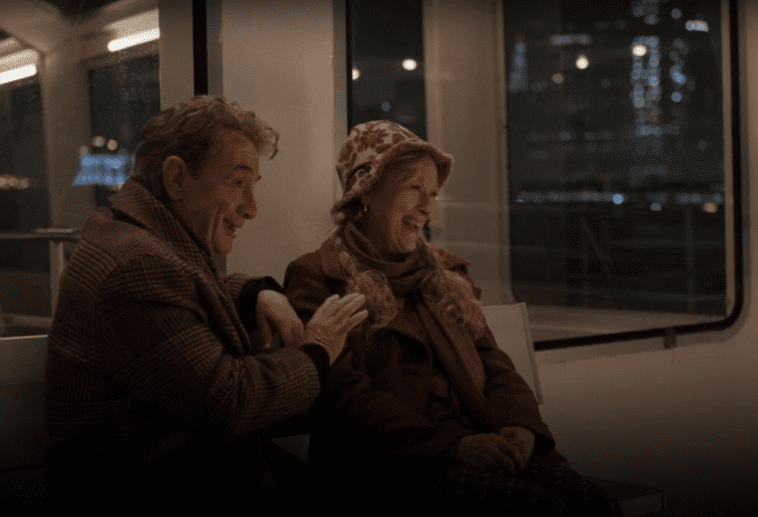 Oliver and Loretta sit on the ferry and laugh in Only Murders in the Building S3E5