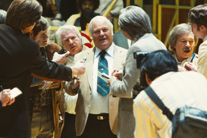 Red Auerbach meets with reporters courtside. 