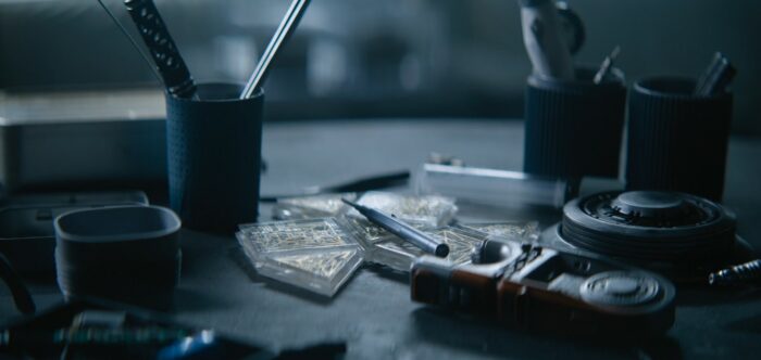 Foundation S2E6 - A desk top shown with various items scattered on top of it