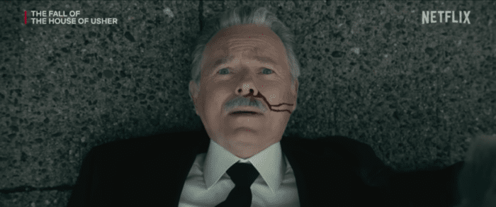 Bruce Greenwood lays on the ground with blood running from his nose.