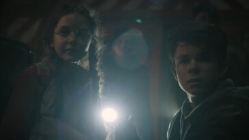 Penny and Monty look on in fear with a light between them as they stand in a tunnel in Invasion S2E4