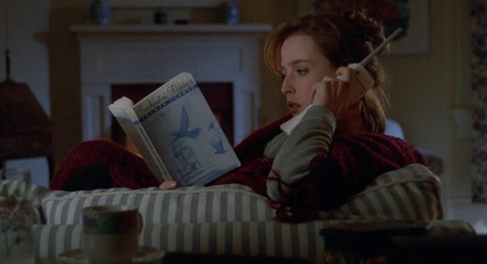 Scully on a portable phone as she reads Truman Capote's Breakfast at Tiffany's