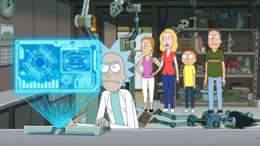 Rick works in his workshop as his family stands behind him.
