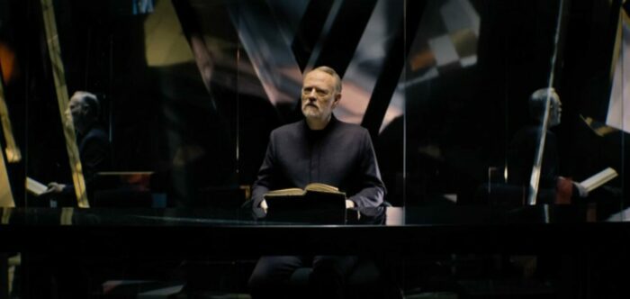 Foundation S2E8 - Dr. Seldon sits at his desk inside the Prime Radiant, a book spread out before him