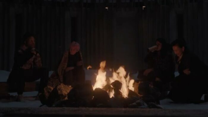 A Murder at the End of the World S1E5 - Martin, Darby, Ziba, and Lu Mei sit around a bonfire in the hotel courtyard at night