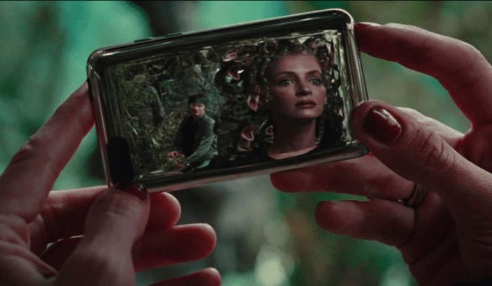 Medusa (Uma Thurman) looking at her reflection with Percy (Logan Lerman) behind her.