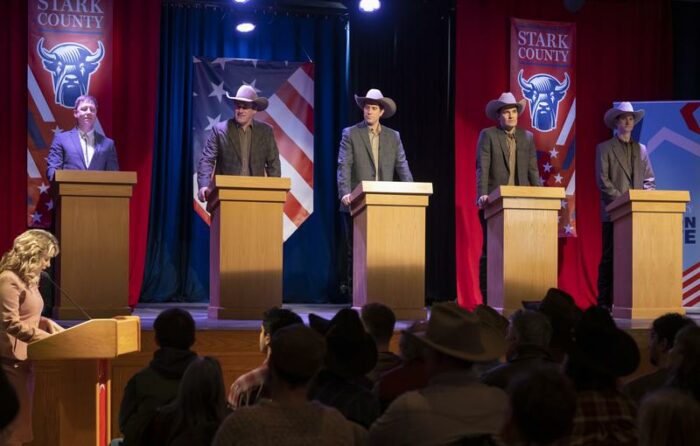 Tillman stands on stage during the debate with three other Tillman's.