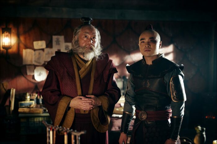 Iroh and Zuko look toward the camera with Zuko's conspiracy board on the wall behind them