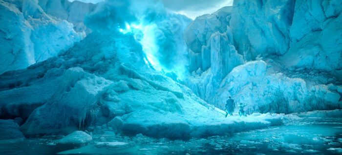 A glowing blue crack in the white icy landscape with Katara and Sokka, tiny, standing at the bottom