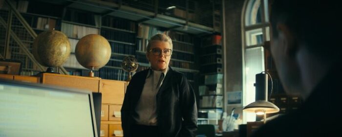 Irena standing in a library in Constellation S1E5