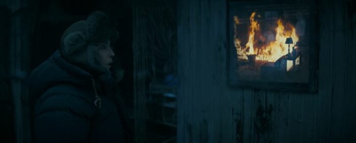 Jo in the cabin, with fire within the painting on the wall