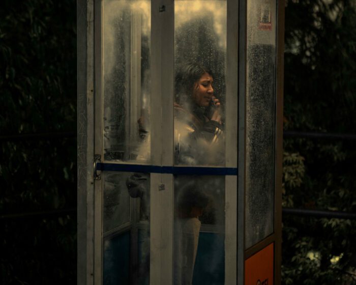 Reena in a phonebooth, frantically calling someone